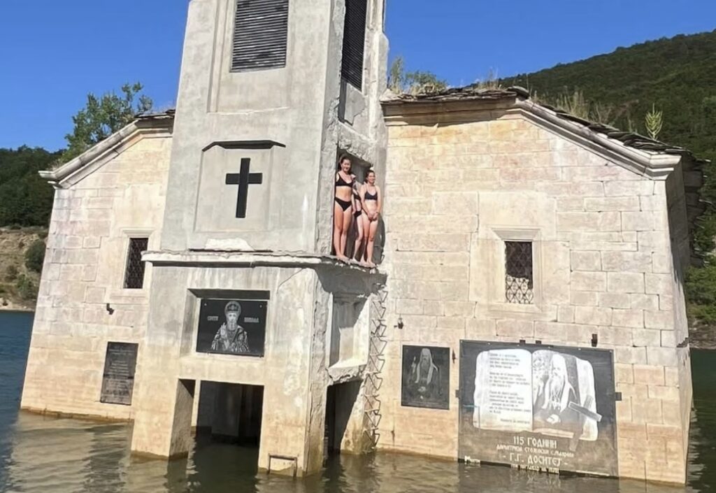 Туристи во купачи се качуваат на потопената црква „Св. Никола“ во Маврово