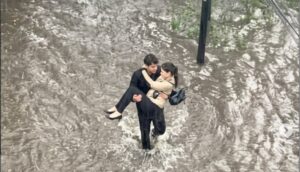 (ВИДЕО+ФОТО) Романтичен момент – Видео од млад човек кој носи девојка во раце низ поплавените улици на Сантијаго ги освои мрежите: Луѓето почнале да аплаудираат